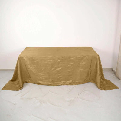 Gold tablecloth on a plain backdrop, perfect for elegant events or decor.