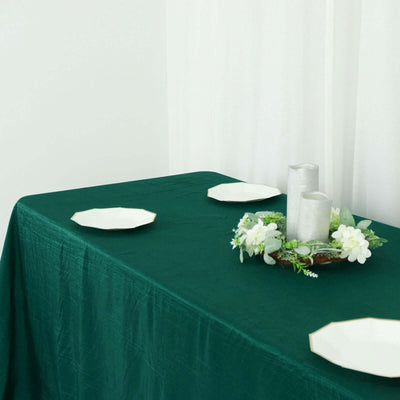 Green table setting with plates and a floral centerpiece.