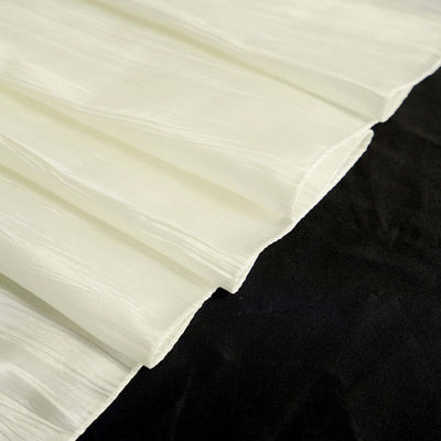 Ivory pleated fabric draped on a dark background.