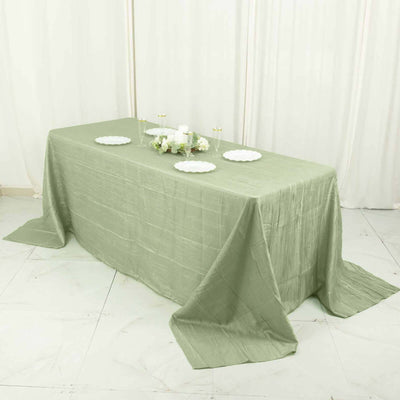 Green tablecloth draped over a table with decorative plates and flowers.