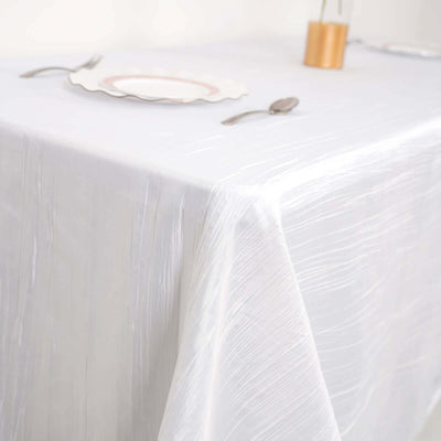 Elegant white tablecloth with subtle texture on a dining table setting.