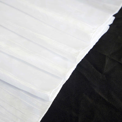 White pleated fabric on black background showcasing texture and design.