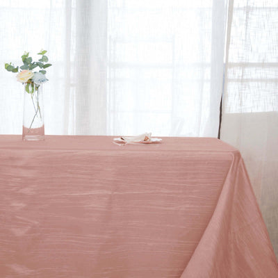 Elegant pink tablecloth draped over a table with a vase of flowers.
