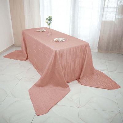 Pink textured tablecloth draped elegantly over a table in a bright room.