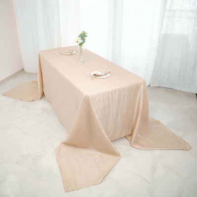 Elegant beige tablecloth draped over a table with floral centerpiece.