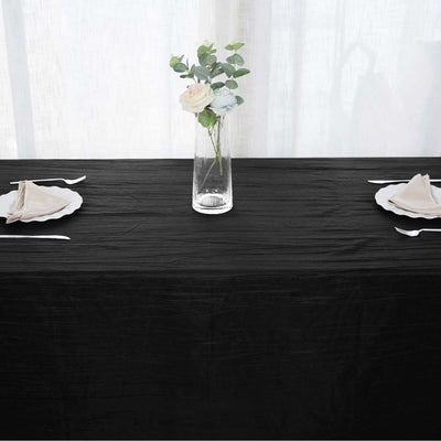 Elegant black tablecloth with a floral centerpiece and table settings.
