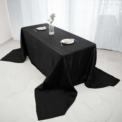 Elegant black tablecloth draped over a dining table with plates and chopsticks.