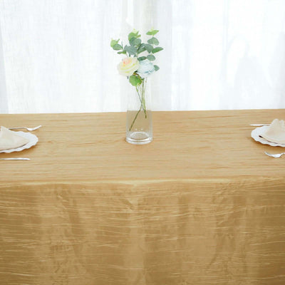 Gold tablecloth with elegant floral centerpiece in a bright setting.