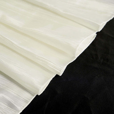Textured white fabric with pleats on a dark background.