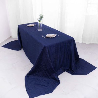 Navy blue tablecloth draped elegantly on a dining table with plates and silverware.