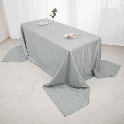 Elegant gray tablecloth draped on a dining table with floral centerpiece.