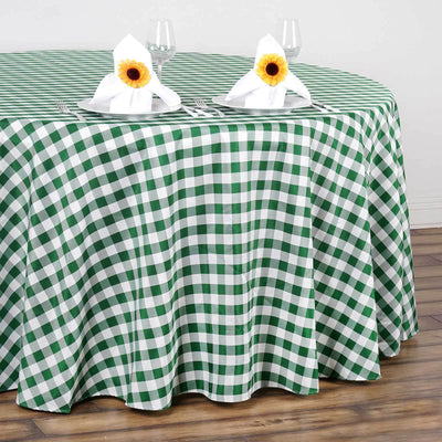 Green and white checkered tablecloth with napkins and sunflowers on a wooden table.