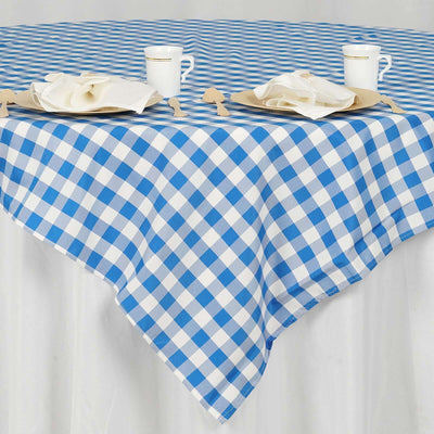 Blue and white checkered tablecloth draped over a table with cups and plates