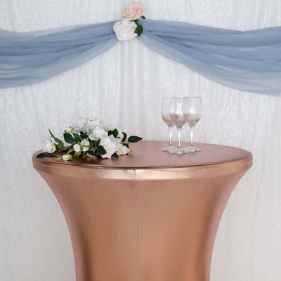 Elegant copper cocktail table with decorative flowers and glasses in a festive setting.
