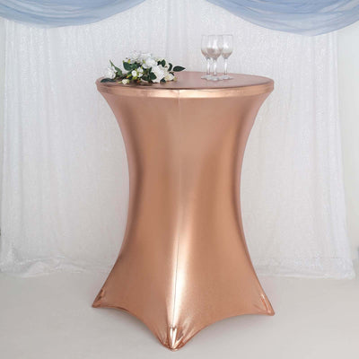 Rose gold cocktail table with floral arrangement and glasses.