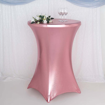 Pink fitted table cover with floral arrangement and glasses on a round table.