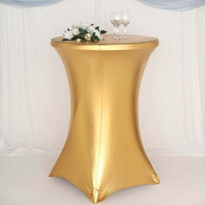 Gold table cover with floral arrangement and glasses in a decorated setting.