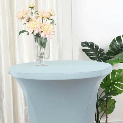 Round light blue table cover with floral centerpiece and greenery.