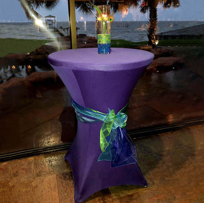 Purple cocktail table with a colorful drink and decorative ribbon.