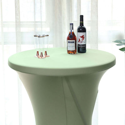 Round green table with drinks and glasses in a bright setting.