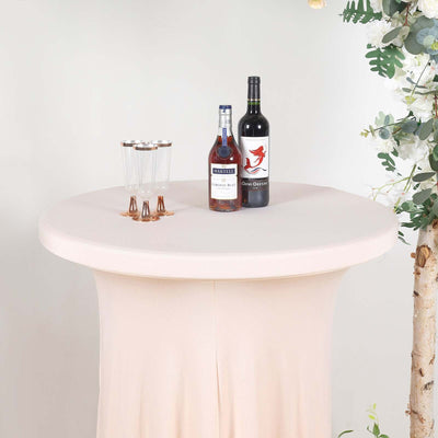 Elegant round bar table with drinks and glasses on a soft beige cover.