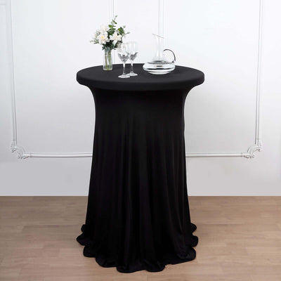 Black stretch table cover with centerpiece, glassware, and decanter.