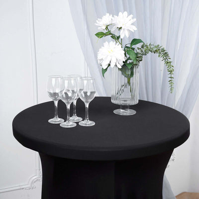 Elegant black table with wine glasses and a floral arrangement.