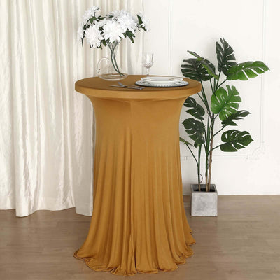 Elegant mustard table cover draping a round table with floral decor and greenery.