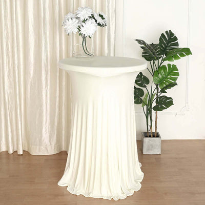 Elegant cream table cover draped on a round table with floral arrangement.