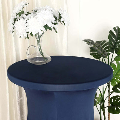 Navy blue table cover with a clear vase of white flowers on a round table.