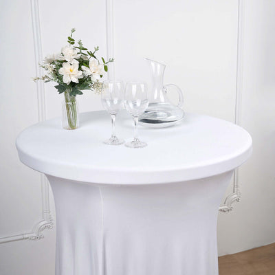 Elegant round table setup with flowers, glasses, and a pitcher.