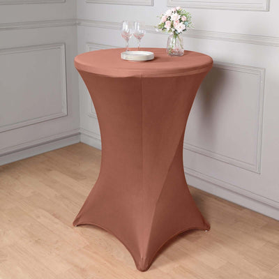 Brown stretch table cover on a round table with drinks and flowers.