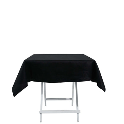 Black tablecloth draped over a folding table on a white background