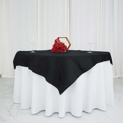 Elegant black and white table setting with roses and glassware.
