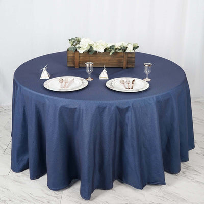 Round navy tablecloth with plates, cutlery, and floral centerpiece.