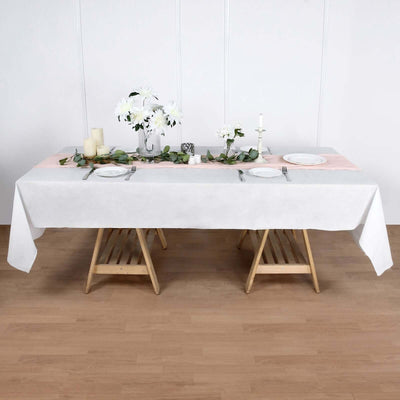 Elegant dining table setup with white tablecloth, flowers, and candles.