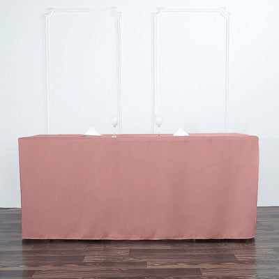 Pink tablecloth draped over a table with glasses and napkins.