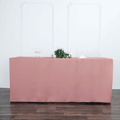 Pink tablecloth draped over a table with glasses and decor.