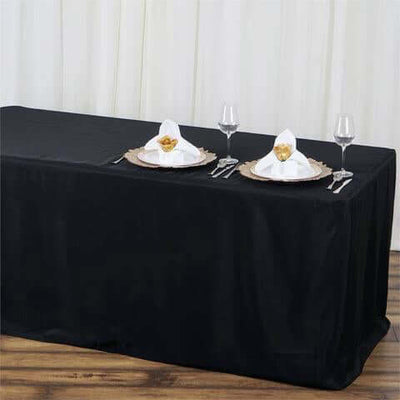 Black tablecloth with elegant table setting for dining.