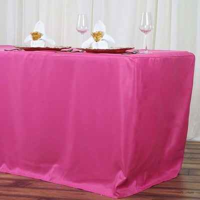 Pink tablecloth draped elegantly over a table set for dining with glasses and napkins.