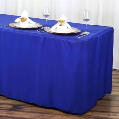 Royal blue tablecloth on a dining table set with elegant napkins and glassware.