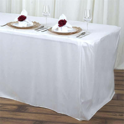 Elegant white tablecloth draped over a table, set for a formal dinner.