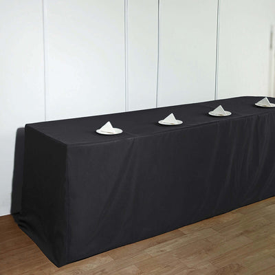 Black table cover with white plates arranged on top.