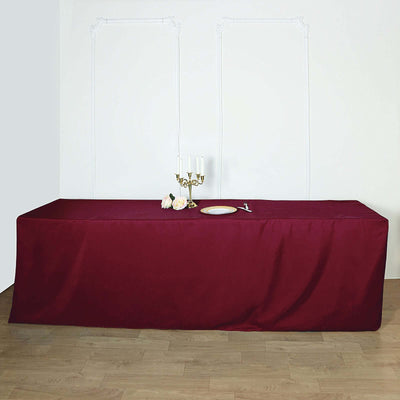 Burgundy tablecloth draped over a table with candles and flowers