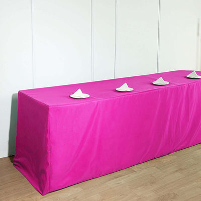 Pink table cover with white napkins on a plain backdrop.