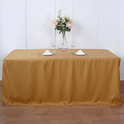 Elegant gold tablecloth draped over a dining table with floral centerpiece.