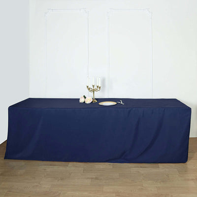 Navy blue tablecloth draped over a long table with candles and decorative plate.