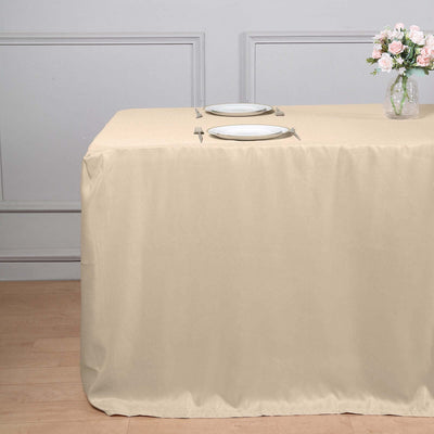 Beige tablecloth draped over a table set for dining.