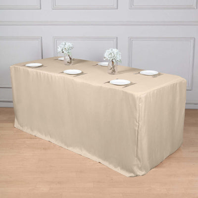 Beige table cover draped over a table with plates and vases.