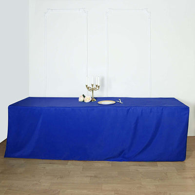 Blue tablecloth draping a long table with a candle holder and decorative plate.